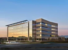 Cadence Design Systems headquarters building in San Jose, California, photographed at dusk with its glass facade lit.