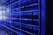 Rows of tower servers with blue indicator lights on shelves in the BalticServers server room.
