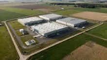 Aerial photograph of the Varde Innovation Campus data center buildings in Denmark, surrounded by farmland with an electricity substation in the foreground.