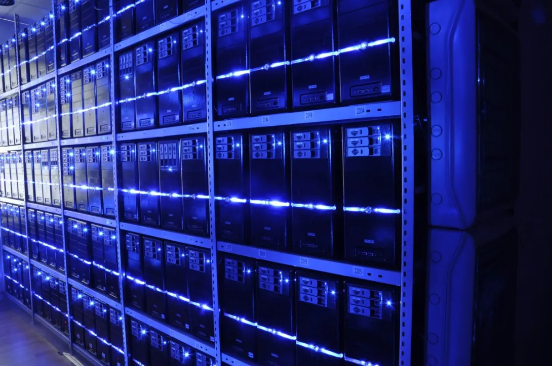Rows of tower servers with blue indicator lights on shelves in the BalticServers server room.